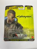 Hot Wheels Premium Pop Culture: Cyberpunk 2077 Porsche 911 Turbo (930) – 1:64 Scale Diecast Car (Real Riders)